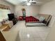 Simple bedroom with tiled floors, dresser, TV, and natural light from the window at 1808 4Th Se Ct, Winter Haven, FL 33880