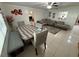 Open living room features tile flooring, a dining table, and a sectional sofa with neutral colors, providing a relaxed atmosphere at 1808 4Th Se Ct, Winter Haven, FL 33880