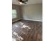 A cozy bedroom with wood-look floors, a ceiling fan and a large window offering ample natural light at 1845 Portview Ave, Deltona, FL 32738