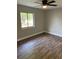 A serene bedroom featuring durable laminate flooring, a ceiling fan and a sunlit window at 1845 Portview Ave, Deltona, FL 32738