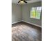 Cozy bedroom showcasing laminate flooring, a ceiling fan and a window with a lush outdoor view at 1845 Portview Ave, Deltona, FL 32738