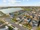 Aerial view of a neighborhood near a lake with sidewalks, lush greenery, and various house models at 19307 Banfield Pl, Orlando, FL 32827