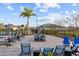 Community pool area with lounge chairs, tables, umbrellas, and manicured landscaping at 19307 Banfield Pl, Orlando, FL 32827