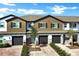 Townhome exterior featuring brick driveways, garages, and well-maintained landscaping at 208 Cape Honeysuckle Pl, Sanford, FL 32771