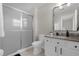 This bathroom features a shower with sliding glass door, a vanity with a granite top and black hardware at 3133 Yellow Lantana Ln, Kissimmee, FL 34747