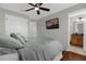 This bedroom features neutral walls, ceiling fan, TV, wardrobe, and a comfortable bed with gray pillows at 3133 Yellow Lantana Ln, Kissimmee, FL 34747