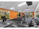 Modern gym featuring new equipment, a large mirror, and an orange accent wall at 3133 Yellow Lantana Ln, Kissimmee, FL 34747