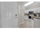 Entryway view of kitchen with white cabinets and stainless steel appliances at 3133 Yellow Lantana Ln, Kissimmee, FL 34747