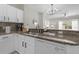 Well-lit kitchen showcasing countertop, stainless steel sink, and white appliances at 3133 Yellow Lantana Ln, Kissimmee, FL 34747