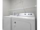 Bright laundry room features modern white washer and dryer units, and functional wire shelving at 3133 Yellow Lantana Ln, Kissimmee, FL 34747