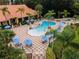 Aerial view of community pool surrounded by lush landscaping, lounge chairs and patio umbrellas at 3133 Yellow Lantana Ln, Kissimmee, FL 34747