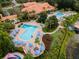 Aerial view of resort style community pool area with lounge seating and tropical landscaping at 3133 Yellow Lantana Ln, Kissimmee, FL 34747