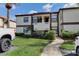 Exterior view of a two story condo building showing well-maintained landscaping at 3467 Flossmoor Ave # 101, Orlando, FL 32822