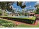 Community pool surrounded by lush landscaping, seating, and shade structures at 3467 Flossmoor Ave # 101, Orlando, FL 32822