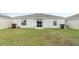 Backyard view of a home featuring a well-maintained lawn, fence, and a sliding glass door at 3920 Guernsey Bnd, St Cloud, FL 34772