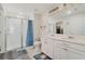 Bright bathroom with double sink vanity, modern lighting, and a glass-enclosed shower, reflecting a clean and functional space at 3920 Guernsey Bnd, St Cloud, FL 34772