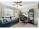 Bedroom with a large window, sofa, bookshelves, desk, and a ceiling fan creating a comfortable and functional space at 3920 Guernsey Bnd, St Cloud, FL 34772