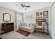 Cozy bedroom featuring a ceiling fan, dresser, framed artwork, and a comfortable sofa with decorative pillows at 3920 Guernsey Bnd, St Cloud, FL 34772