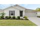 Beautifully landscaped front yard of a single-story home with dark shutters and a gray facade at 3920 Guernsey Bnd, St Cloud, FL 34772