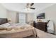 Comfortable bedroom with ceiling fan, a comfortable bed, and large windows at 3920 Guernsey Bnd, St Cloud, FL 34772