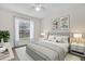 Cozy bedroom showcasing a tufted headboard, soft bedding, and natural light from a window at 3960 Southpointe Dr # 509, Orlando, FL 32822