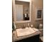 Well-lit bathroom featuring granite counters, white sink and a decorative mirror at 419 Aldama Ave, Lady Lake, FL 32159