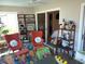 Bright sunroom with red chairs, decorative shelving, and colorful rug at 419 Aldama Ave, Lady Lake, FL 32159