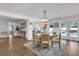 Bright dining area with modern chandelier, wood floors and an open design connecting to the kitchen and pool at 5205 Saint Regis Pl, Belle Isle, FL 32812