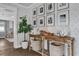 Inviting entryway with wood table, baskets, a lush fig tree, and beautiful black and white Gathering photos on display at 5205 Saint Regis Pl, Belle Isle, FL 32812