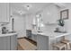 Bright and updated kitchen featuring white cabinets, gray island, stainless appliances, and modern fixtures at 5205 Saint Regis Pl, Belle Isle, FL 32812