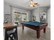 Game room features a pool table, ceiling fan, and access to outdoor entertaining area at 548 Hebrides Ct, Apopka, FL 32712