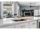 Modern kitchen island with white countertop, gold faucet, and stainless steel sink with cutting board insert at 548 Hebrides Ct, Apopka, FL 32712