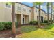 Exterior townhome view showing the front facade with a well-maintained lawn and landscaping at 6007 Scotchwood Gln # 37, Orlando, FL 32822