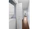 Hallway with washer and dryer closet, plus wood floors leading to the primary bedroom at 6007 Scotchwood Gln # 37, Orlando, FL 32822