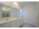 Bright bathroom featuring double sinks, quartz countertop vanity, and tiled shower at 6140 Shavasana Rd, Clermont, FL 34714