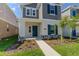 Charming two-story home with gray shingles, teal shutters, manicured lawn, and walkway at 6140 Shavasana Rd, Clermont, FL 34714