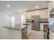 Modern, open-concept kitchen featuring an island, stainless steel appliances, and white cabinetry at 6140 Shavasana Rd, Clermont, FL 34714