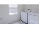 Well-lit laundry room features modern washer and dryer units and tiled floors at 6140 Shavasana Rd, Clermont, FL 34714