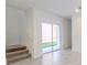 Bright living room with sliding glass doors leading to the backyard and carpeted stairs at 6140 Shavasana Rd, Clermont, FL 34714