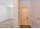 Hallway featuring neutral walls and carpets leading to a laundry room with washer and dryer hookups, plus a view into a bedroom at 6230 Shavasana Rd, Clermont, FL 34714