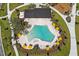 Aerial view of a community pool featuring lounge chairs, umbrellas, and a nearby recreation area at 6383 Trailblaze Bnd, St Cloud, FL 34771