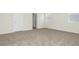 Bedroom with grey carpet, white walls, two windows and doors at 6383 Trailblaze Bnd, St Cloud, FL 34771