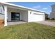 Exterior view of house featuring attached garage, sliding glass door, and lush green lawn at 6383 Trailblaze Bnd, St Cloud, FL 34771