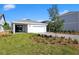 View of garage from yard with short brick paver driveway with grass at 6383 Trailblaze Bnd, St Cloud, FL 34771