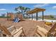 A playground with wooden play structures and lounge chairs with nearby homes in the background at 6383 Trailblaze Bnd, St Cloud, FL 34771