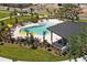 Aerial view of a pool featuring lounge chairs, umbrellas, and a nearby recreation area at 6383 Trailblaze Bnd, St Cloud, FL 34771