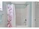 Bathroom features a shower and tub with floral shower curtain and blue walls at 647 Holbrook Ave, Deltona, FL 32738