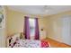 Bright bedroom features a ceiling fan, window with purple curtains, and white dresser at 647 Holbrook Ave, Deltona, FL 32738