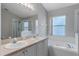 Bathroom with a large soaking tub, glass-enclosed shower, and dual sinks at 763 Via Milano, Apopka, FL 32712