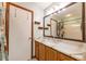 Bathroom features wood cabinets, granite counters, framed mirror, and walk-in shower at 7978 Se 174Th Belhaven Loop, The Villages, FL 32162